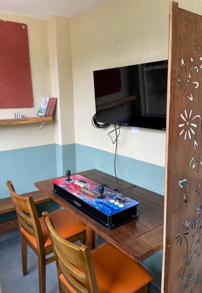 Un espace repas comprenant une table, des chaises, un téléviseur fixé au mur et un panneau décoratif.