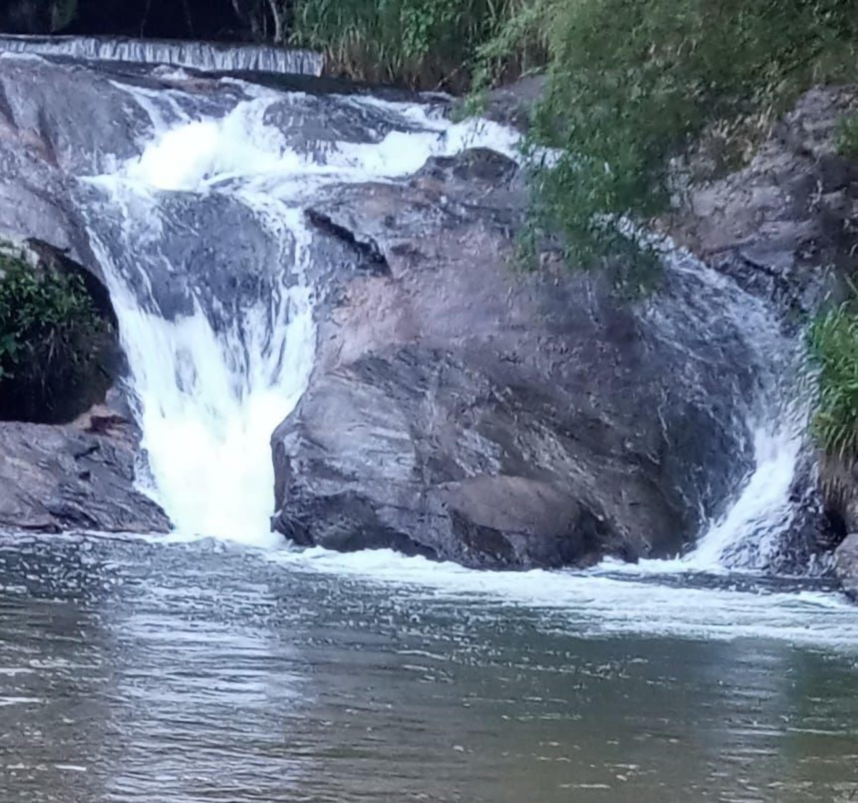 A waterfall cascading over rocks into a body of water.