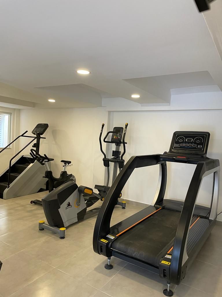 Gimnasio en casa con cinta de correr, elíptica y escaladora.