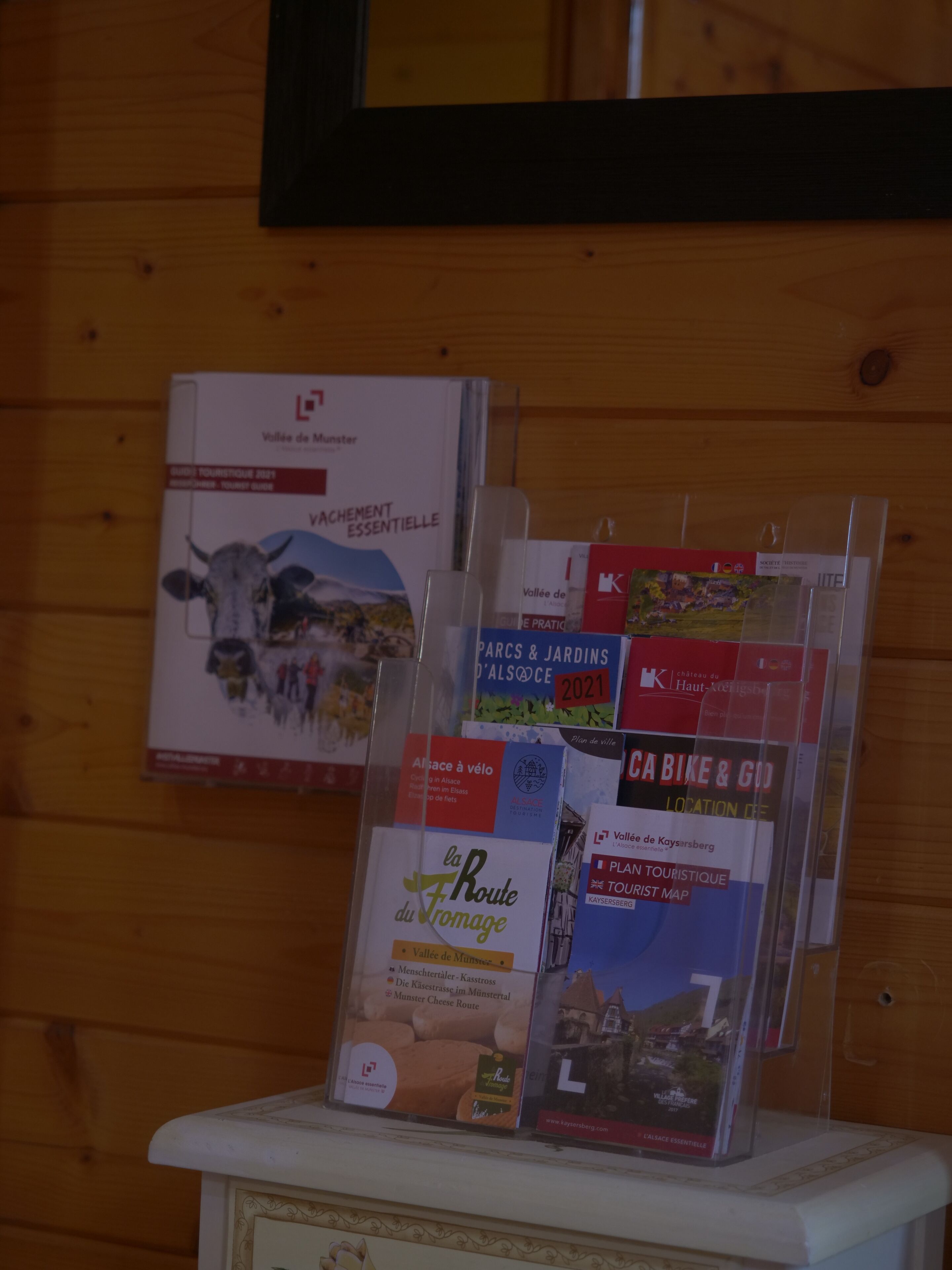 A display of brochures on a wooden shelf.