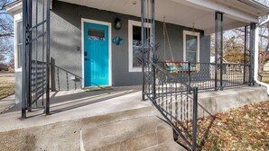 A house with a blue door, a porch with a swing, and a metal gate. - This townhouse is a 1 bedroom(s), 1 bathrooms, located in Wichita, KS. (Wichita)