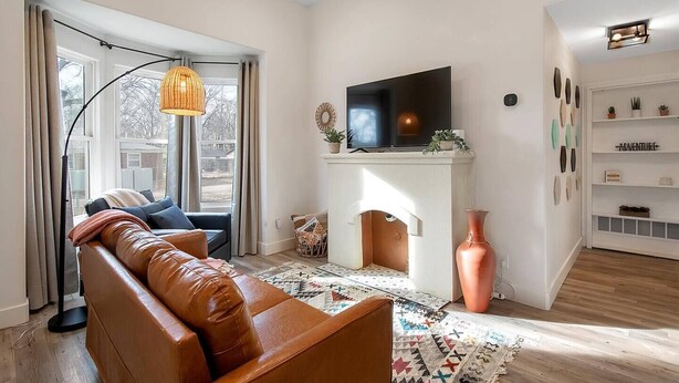 A modern living room with a leather sofa, a flat-screen TV, a fireplace, and a bookshelf. - This townhouse is a 1 bedroom(s), 1 bathrooms, located in Wichita, KS. (Wichita)