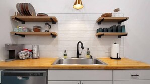 A modern kitchen with a stainless steel sink, wooden countertops, and built-in shelves for storage. - This townhouse is a 1 bedroom(s), 1 bathrooms, located in Wichita, KS. (Wichita)