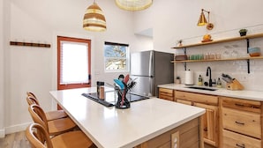 A modern kitchen with a central island, wooden cabinets, and a stainless steel refrigerator. - This townhouse is a 1 bedroom(s), 1 bathrooms, located in Wichita, KS. (Wichita)
