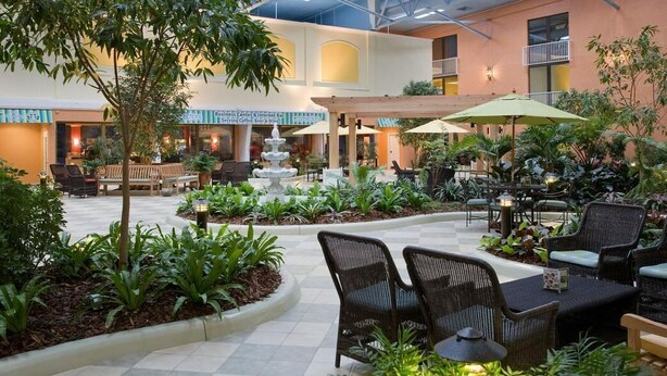 An indoor courtyard with seating areas, a fountain, and a Business Center. - Holiday Inn Vacation club Orange Lake (Kissimmee)