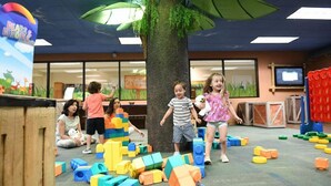 Children playing with colorful building blocks in a room with a tree and a 'Bears & Buddies' sign. - Holiday Inn Vacation club Orange Lake (Kissimmee)