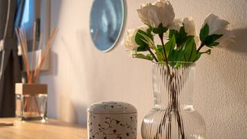 Un vase en verre transparent contenant des fleurs blanches, posé sur une table en bois.