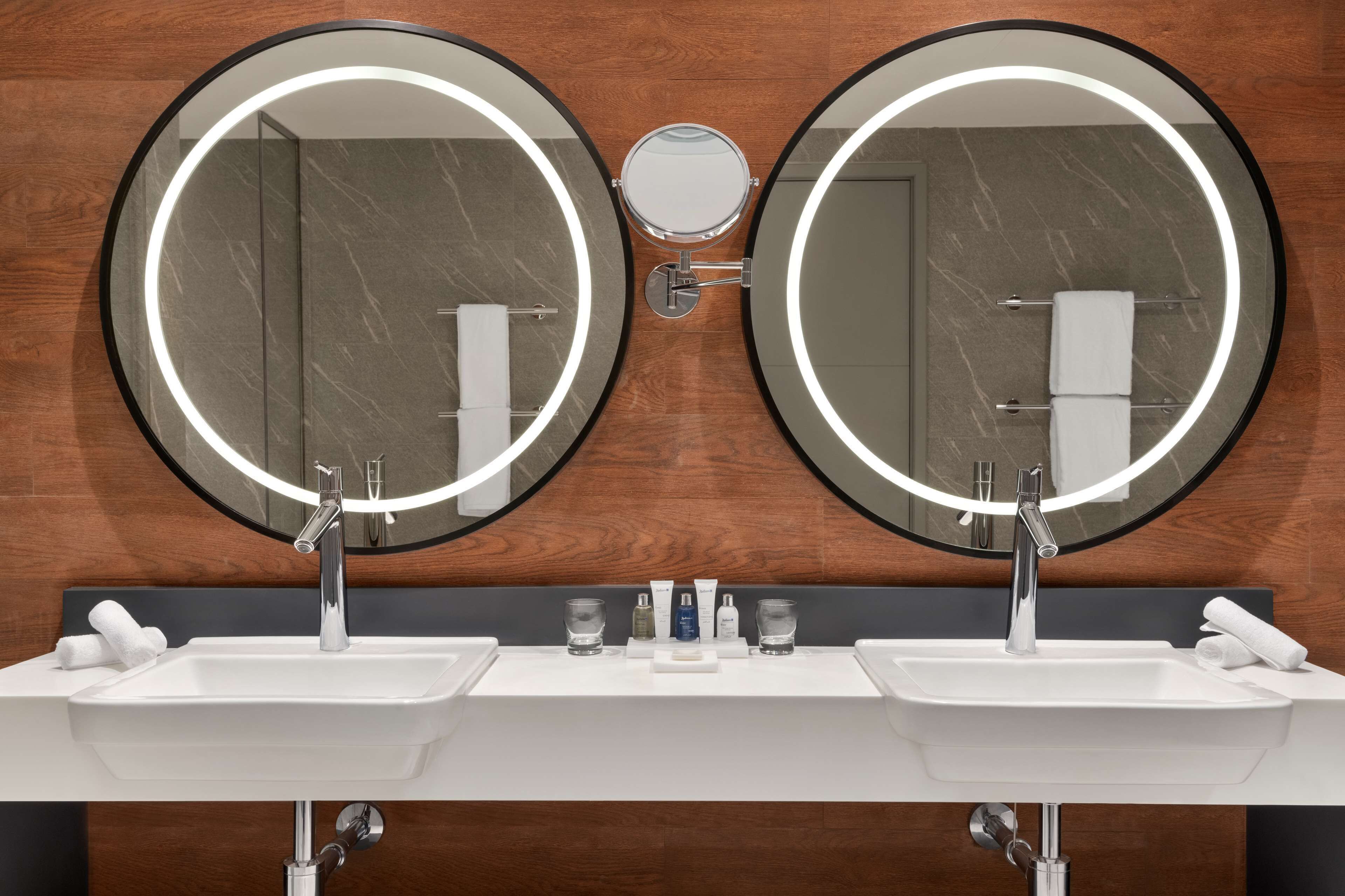 A bathroom with two sinks, a mirror, and a towel rack.