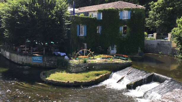 Un hôtel situé au bord de la rivière, doté d’une terrasse, d’un espace extérieur aménagé et d’une petite cascade.