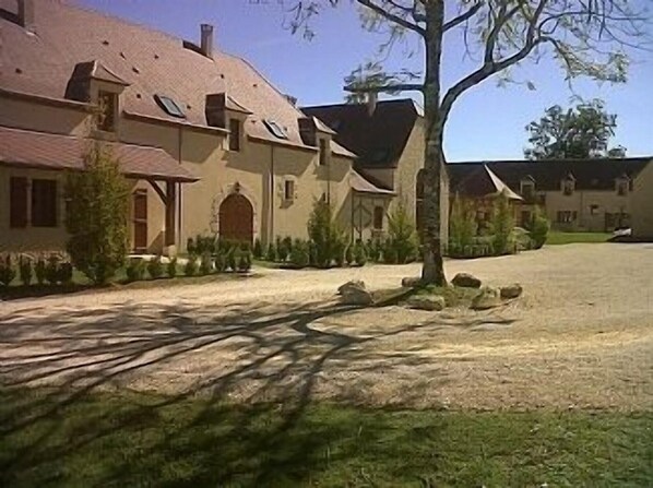 A large, single-story building with a sloped roof, multiple windows, and a well-maintained lawn.
