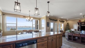 A spacious kitchen with a large island, wooden cabinetry, and pendant lighting.