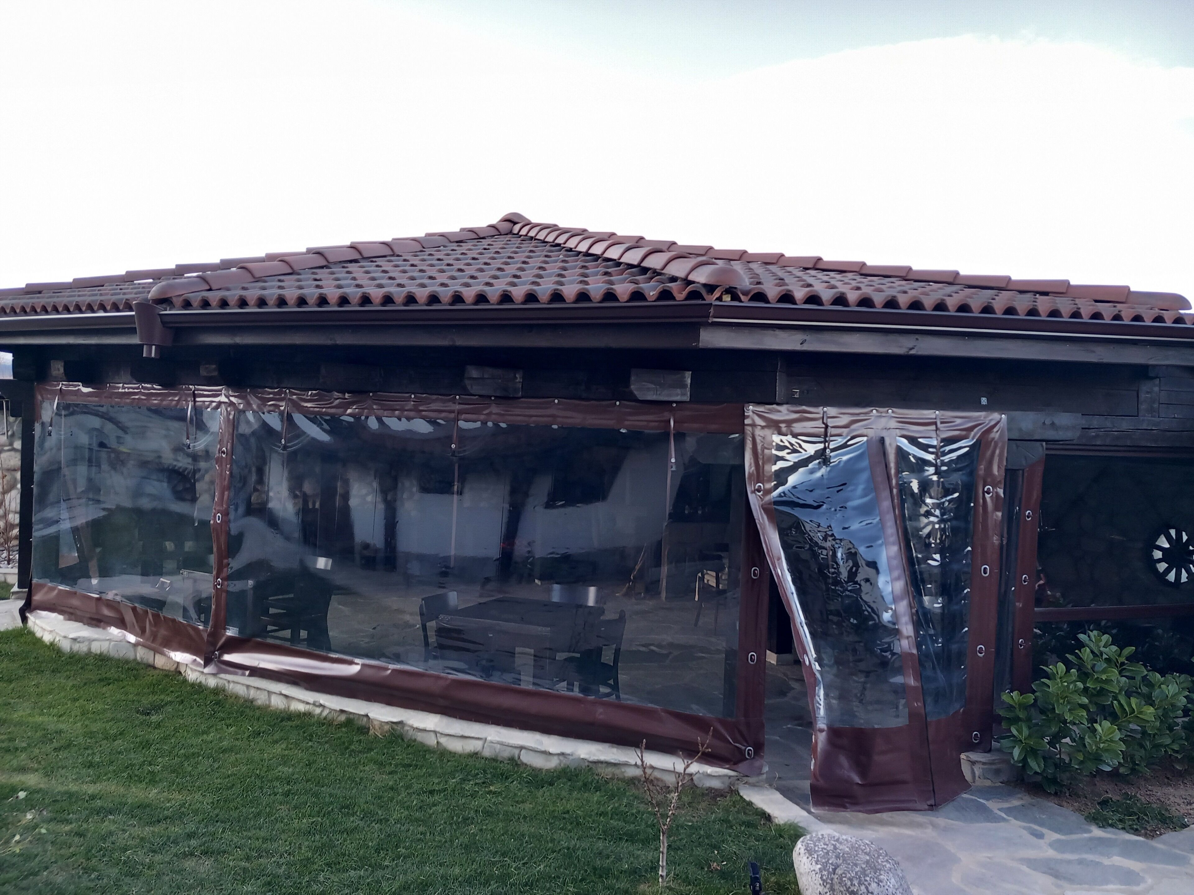 A house with a tiled roof and large glass windows.