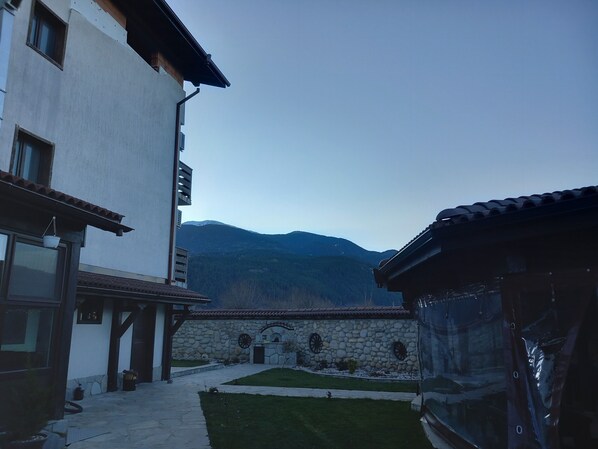 A building with a stone wall and a view of mountains.