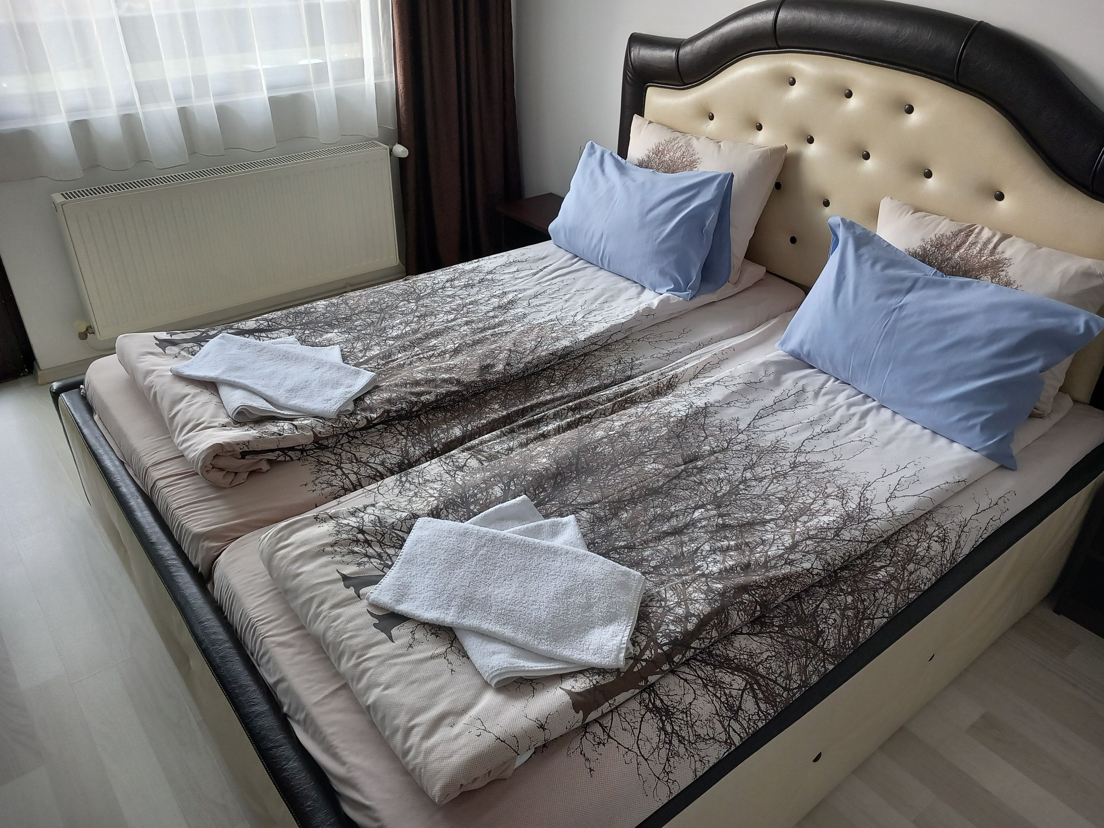 A double bed with a patterned bedspread, two pillows, and a headboard.