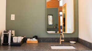 A bathroom with a large mirror, a coffee maker, and a sink. - NEW! Signature Spa Suite with Fireplace & Den (Whittier)