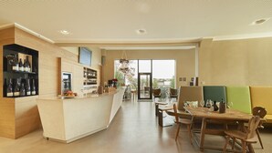 Cozinha espaçosa com ilha central, área de jantar com móveis de madeira e uma grande janela com vista para o exterior.