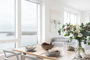 A dining table set with plates, bowls, and a vase with flowers.