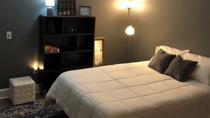 A bedroom with a bed, bedside lamp, and a nightstand. - Charming 3-bedroom house in lovely downtown Madison. (Madison)