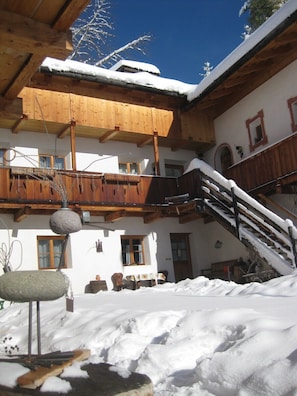 A wooden chalet with a balcony, a staircase, and a snow-covered roof. - Fantastic opportunities to experience a varied holiday!
Historical Guest House (Lajen)