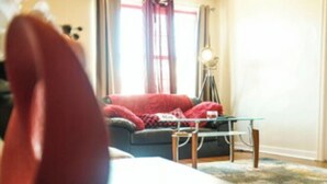 A living room with a sofa, a coffee table, and a lamp. - 2BR 1B APT MINS TO DOWNTOWN (Pittsburgh)