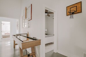 A room with a foosball table, a basketball hoop, and a ceiling fan. - Afton Clubhouse: Central to Wineries + Hot Tub (Afton)