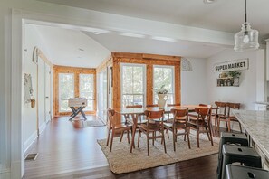 A spacious kitchen with wooden cabinets, a dining area with a large table and chairs, and a sign reading "Super Market".