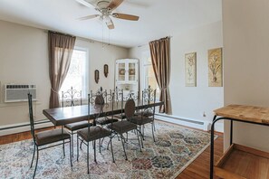 Enjoy meals in this cozy dining room with a wooden table and four chairs, a patterned rug, and framed botanical prints on the wall.