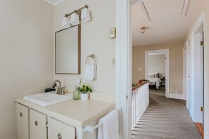 A bathroom with a double sink, mirror, towel rack, and a potted plant. - Oma's Garden Oasis: Spacious, Walk to Park (Staunton)