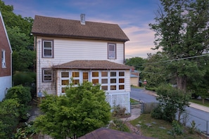 Ein zweigeschossiges Haus mit Veranda, Garage und einem Stoppschild auf der Einfahrt.