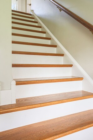 Een trap met houten treden en witte wanden.