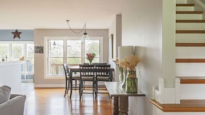 A dining area with a wooden table, chairs, and a hanging light fixture. - Ridgeview Retreat: Mountain Views and Pet Friendly (Staunton)