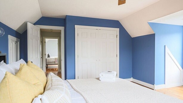 A bedroom with a large bed, a white door, and a blue wall. - Ridgeview Retreat: Mountain Views and Pet Friendly (Staunton)