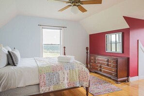 Un dormitorio con cama, cómoda y ventilador de techo.