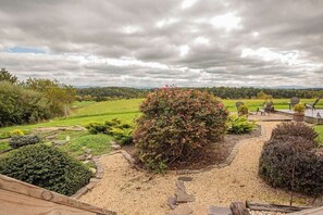 A landscaped garden with a variety of plants and a seating area with chairs.
