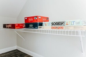 Une étagère contenant divers jeux de société, notamment Scrabble, Monopoly et Sorry!