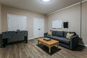 A room with a foosball table, a sofa, and a coffee table. - Ridgeview Retreat: Mountain Views and Pet Friendly (Staunton)
