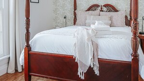A four-poster bed with a wooden frame and white bedding, a ceiling fan, and a patterned wallpaper. - The Landmark: Luxury In Downtown Staunton (Staunton)