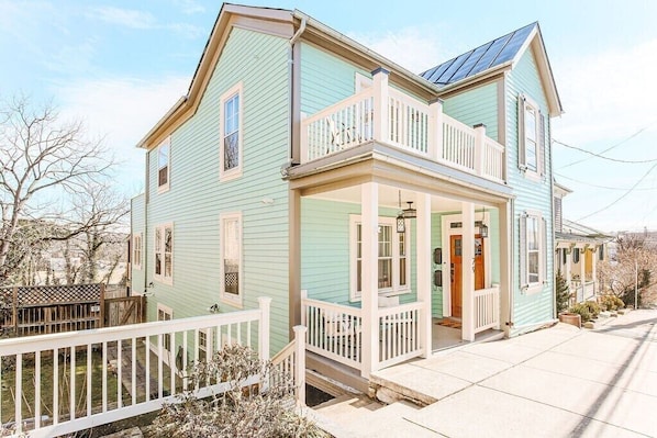 A two-story house with a front porch, a balcony, and a garage.