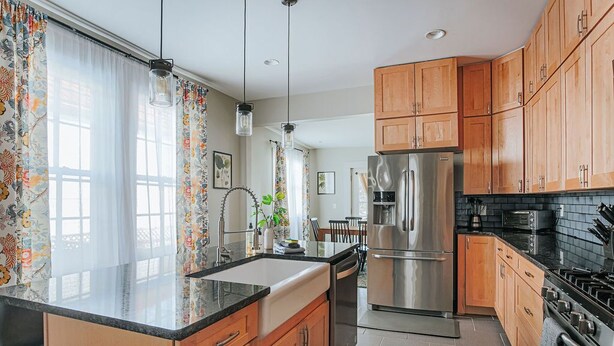 A modern kitchen with wooden cabinets, stainless steel appliances, and a black countertop. - The Landmark: Luxury In Downtown Staunton (Staunton)