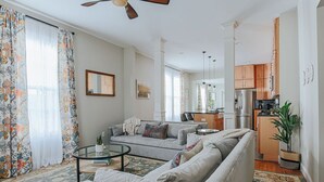 A spacious living room with a grey sofa, a coffee table, and a dining area in the background. - The Landmark: Luxury In Downtown Staunton (Staunton)