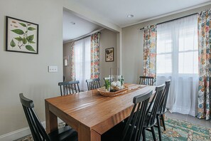 Comedor con mesa de madera, sillas negras y un centro de mesa decorativo.