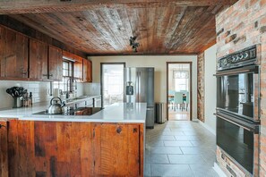 Una cocina con armarios de madera, un refrigerador de acero inoxidable y un horno empotrado.