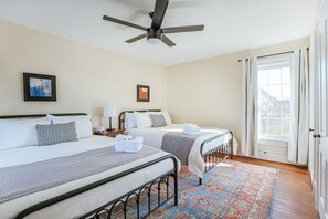 A hotel room with two beds, a ceiling fan, a window with curtains, and a patterned rug. - The Farmhouse at Wellington: Waynesboro, Sleeps 12 (Waynesboro)
