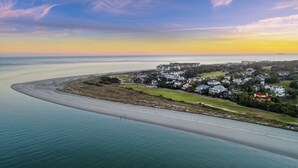 An aerial view of a coastal town with a beach, houses, and a clear sky. - STUNNING Oceanfront Home! Golf & Ocean Views, Hot Tub, Golf Cart, Pool Access! (Isle Of Palms)