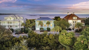 A coastal property with multiple buildings, a beach view, and lush greenery. - STUNNING Oceanfront Home! Golf & Ocean Views, Hot Tub, Golf Cart, Pool Access! (Isle Of Palms)