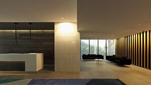 Eine moderne Lobby mit einer Rezeption, einer schwarzen Couch und einem Couchtisch.