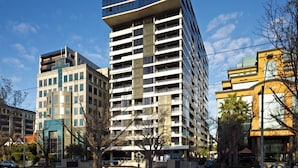 Ein mehrstöckiges Gebäude mit modernem architektonischen Design, das Glas- und Betonelemente kombiniert.
