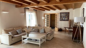 A living room with a beige sectional sofa, a coffee table, and a lamp. - Individual house .  (Le Bois plage)