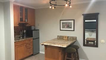 Een koelkast, een magnetron, een koffiezetapparaat/waterkoker, eettafels