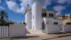 A white building with a cylindrical tower, a gated entrance, and a cobblestone pathway. - QuietPrivateVilla - superwiffi (Lagos)